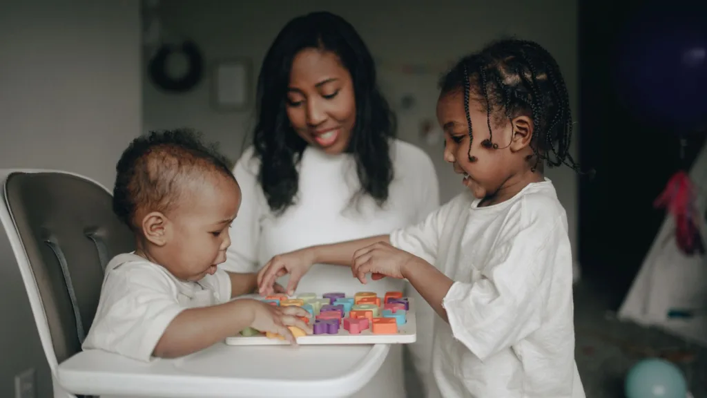 A parent and children playing together with colourful building blocks