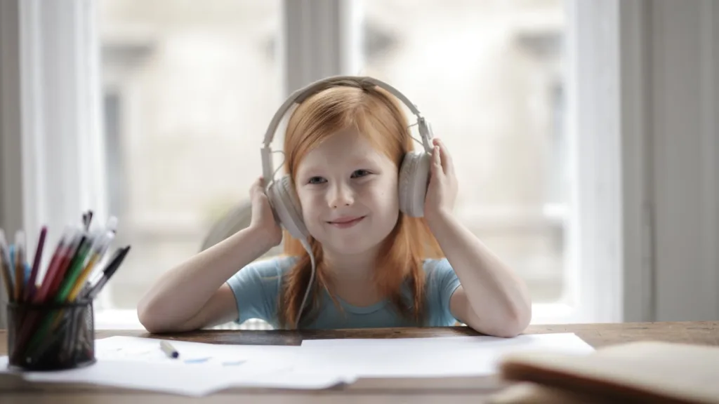 A child wearing over-ear headphones at a table